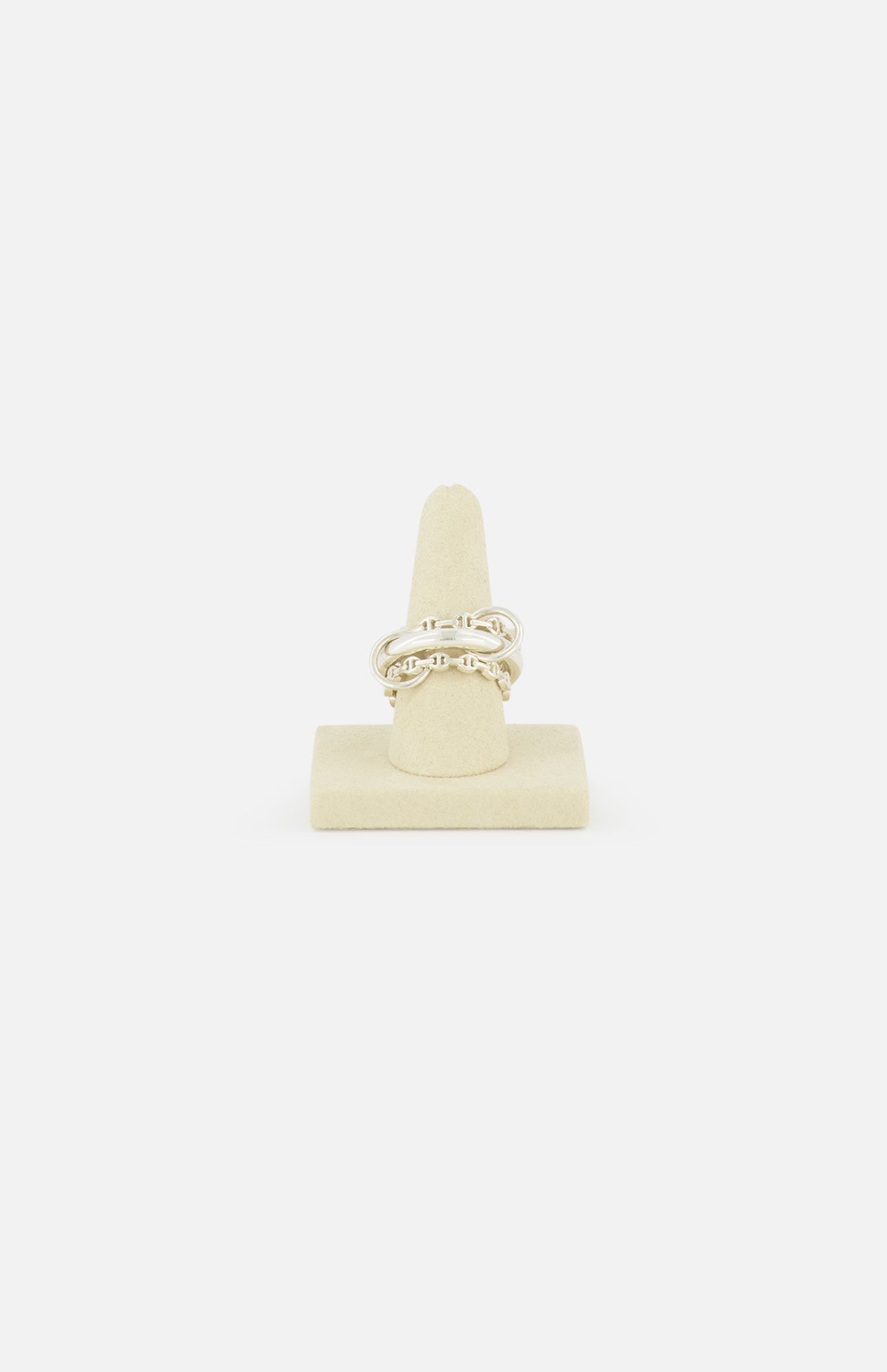 The Microdame SK Ring by SPINELLI KILCOLLIN features an interlocking chain design inspired by modular jewelry, shown upright on a beige ring stand against a plain white background.