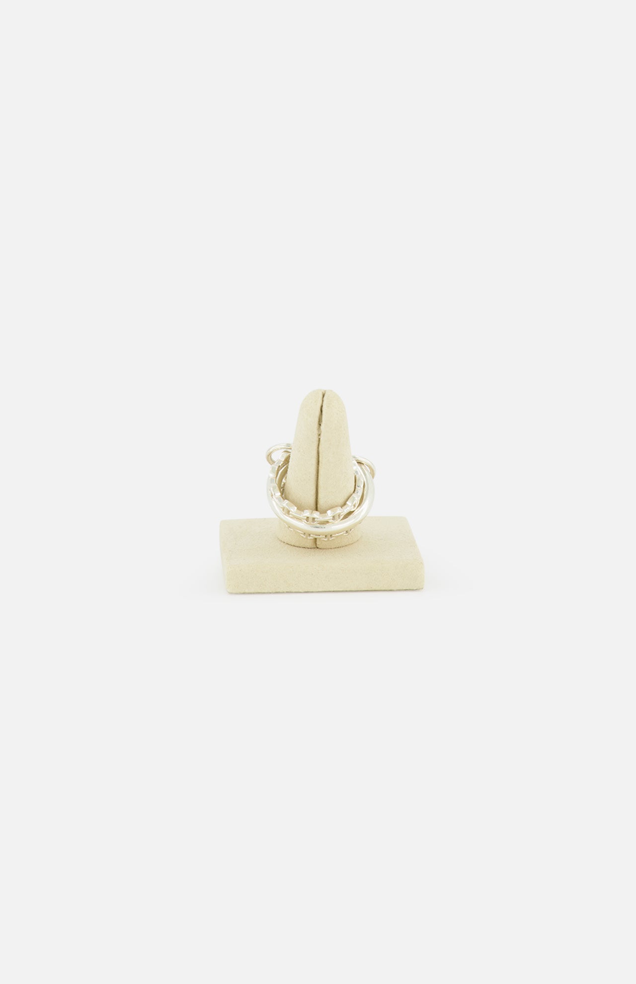 The Microdame SK Ring by SPINELLI KILCOLLIN, inspired by modular jewelry, is displayed on a beige stand against a plain white background.