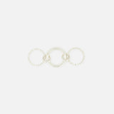 The SPINELLI KILCOLLIN Microdame SK Ring features three interlocking sterling silver bands: a smooth, solid center ring flanked by two textured, beaded rings, all arranged horizontally on a plain white background.