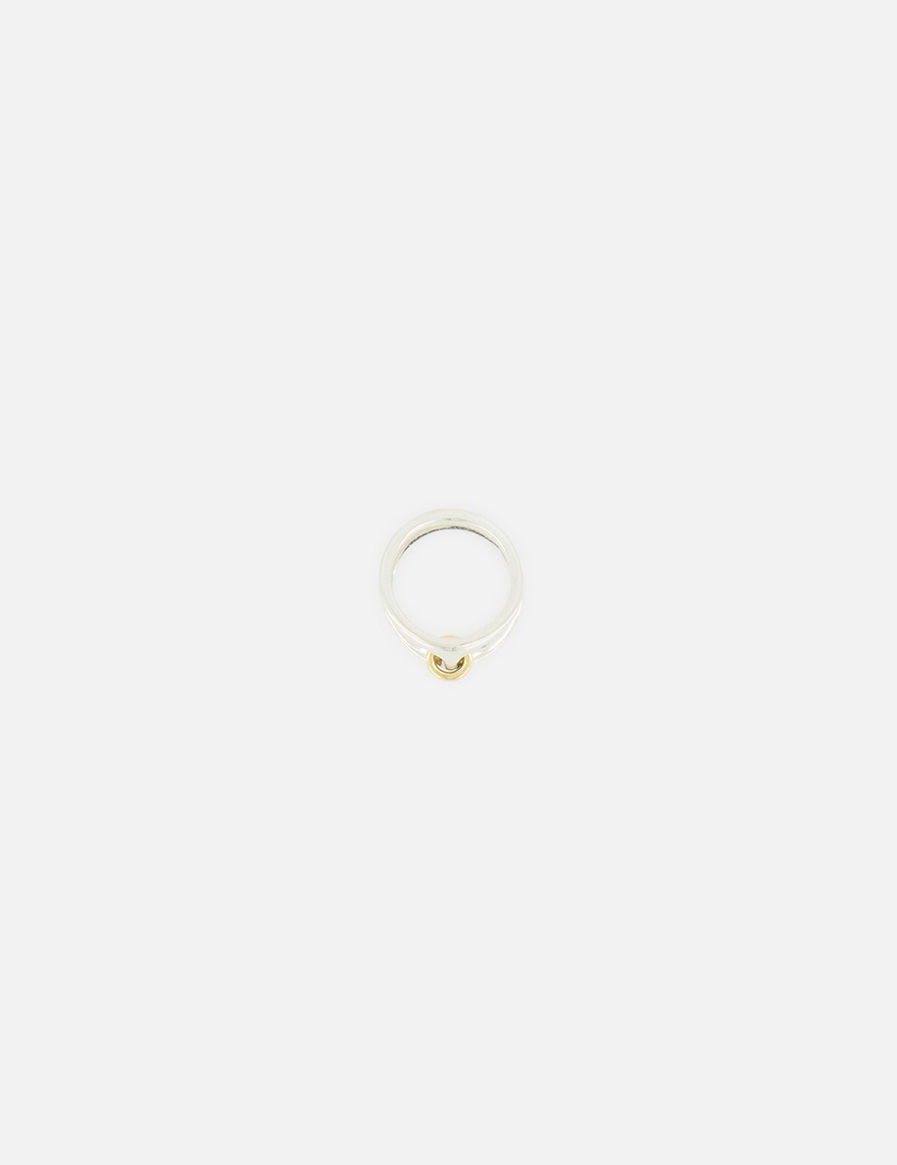 The Phantom SK Ring by SPINELLI KILCOLLIN is a minimalistic sterling silver and yellow gold ring with a small gold accent, shown against a plain white background.