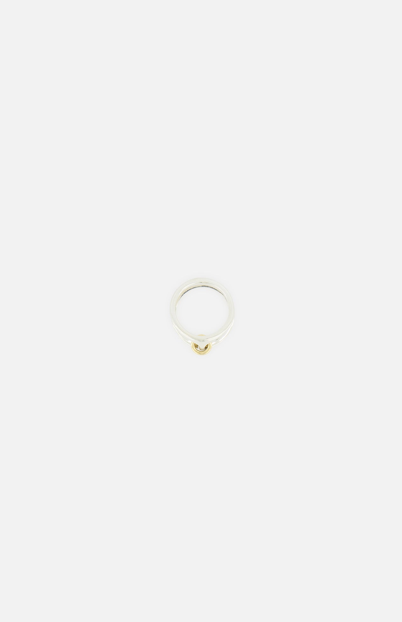 The Phantom SK Ring by SPINELLI KILCOLLIN is a minimalistic sterling silver and yellow gold ring with a small gold accent, shown against a plain white background.