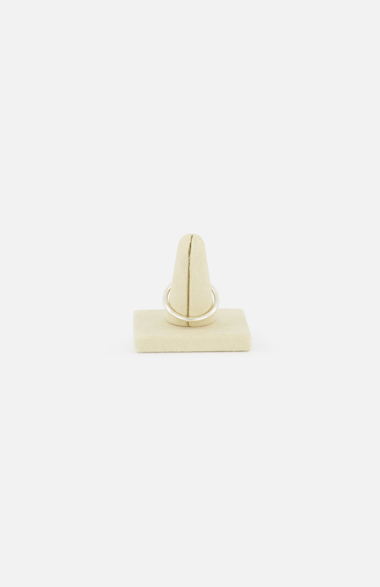 The SPINELLI KILCOLLIN Sirius 3 Annulets Ring, a minimalist unisex gold jewelry piece, is shown upright on a beige velvet ring holder against a plain white background.