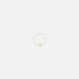 The SPINELLI KILCOLLIN Sirius 3 Annulets Ring features a minimalist sterling silver band with a central small round gold bead, making it an ideal unisex accessory. Shown against a plain white background.