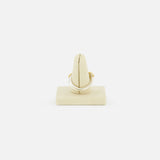 The Solarium SG 3 Band Ring by SPINELLI KILCOLLIN, inspired by minimalism, is displayed on a beige velvet stand and shown from the front against a plain white background.