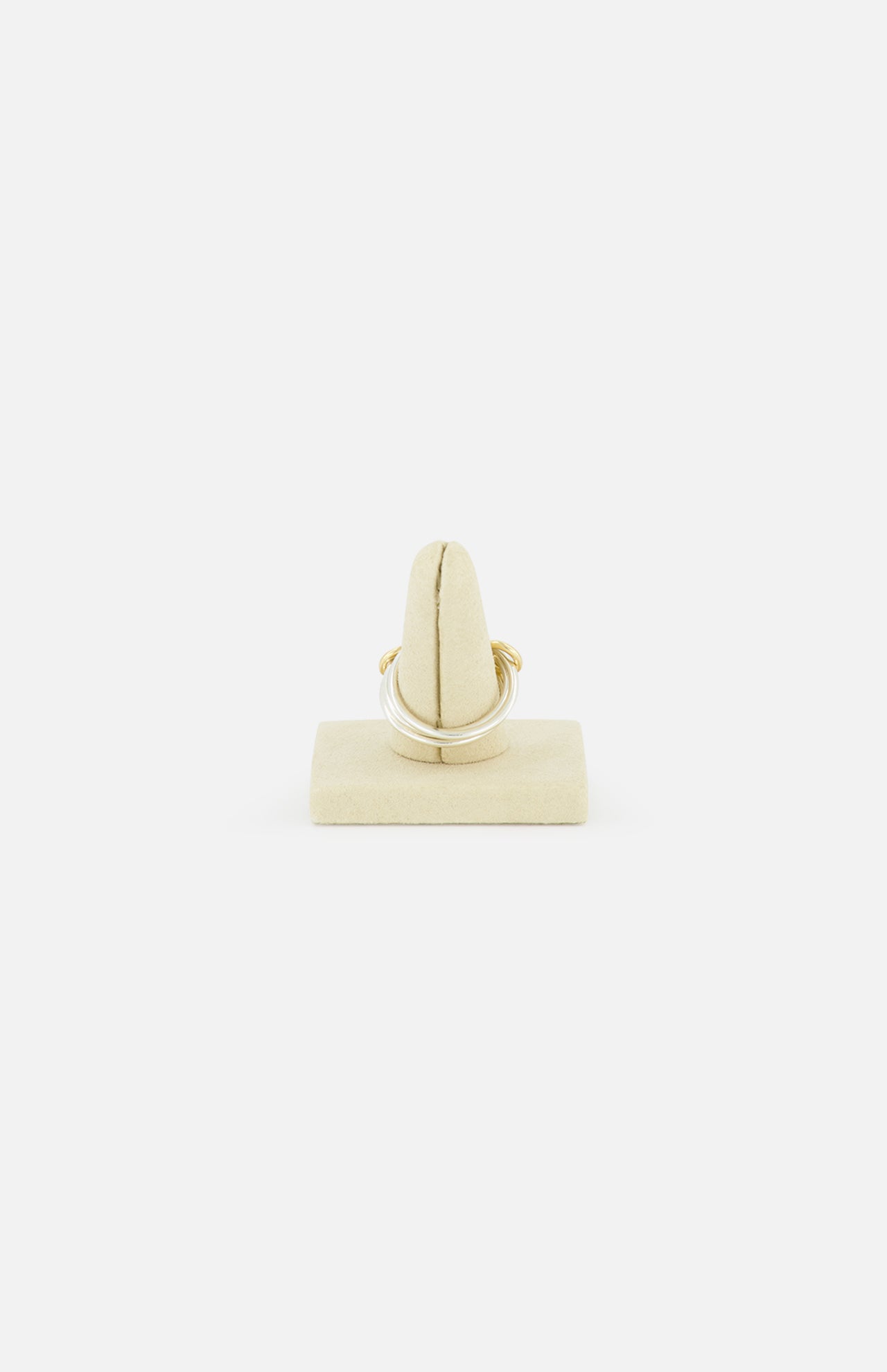 The Solarium SG 3 Band Ring by SPINELLI KILCOLLIN, inspired by minimalism, is displayed on a beige velvet stand and shown from the front against a plain white background.