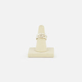 The SPINELLI KILCOLLIN Jovie Double Pave Ring, featuring an abstract intertwined sterling silver design, is displayed on a beige ring stand against a plain white background.