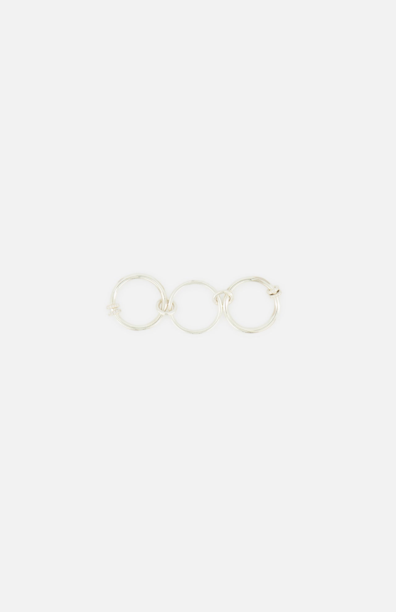 The Jovie Double Pave Ring by SPINELLI KILCOLLIN features interlinked sterling silver bands in a minimalist style, reflecting the brand’s signature elegance against a simple white background.