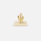 The SPINELLI KILCOLLIN Polaris 4 Band Ring in yellow gold features a textured design, displayed on a beige velvet holder with a white background—ideal for stacking with diamond bands or enhancing your modular jewelry collection.