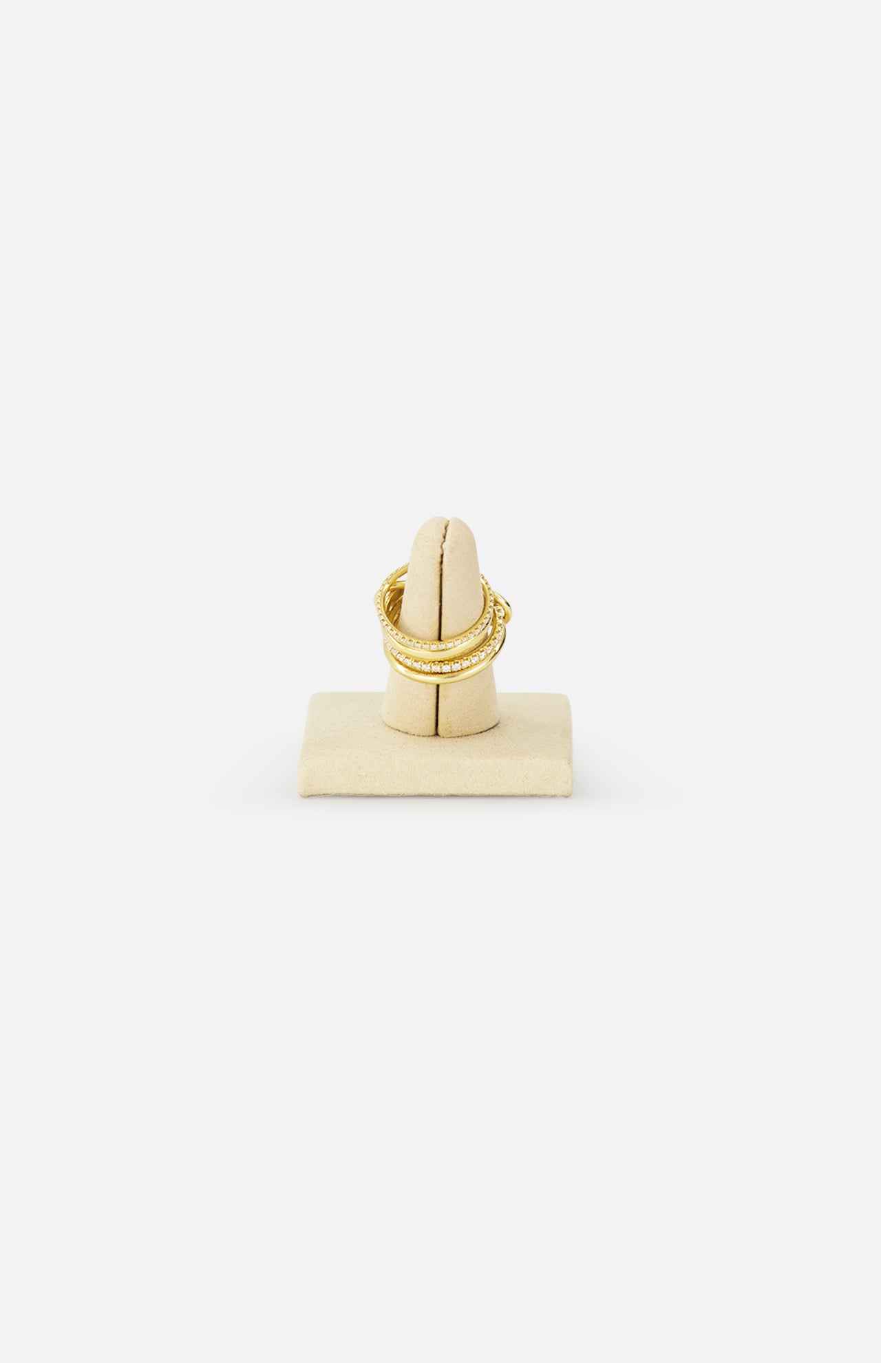 The SPINELLI KILCOLLIN Polaris 4 Band Ring in yellow gold features a textured design, displayed on a beige velvet holder with a white background—ideal for stacking with diamond bands or enhancing your modular jewelry collection.