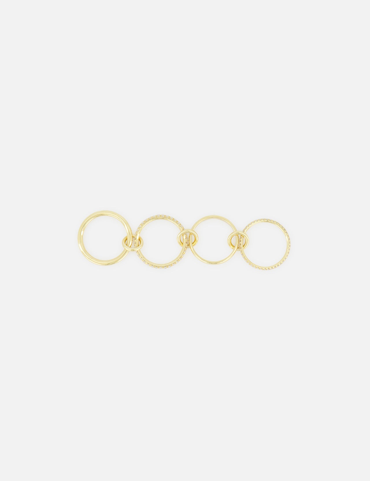 The Polaris 4 Band Ring by SPINELLI KILCOLLIN features four elegantly linked gold bands of varying sizes, arranged in a straight line against a plain white background.