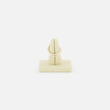 A SPINELLI KILCOLLIN Solarium 3 Band Ring, crafted from sterling silver and yellow gold, is displayed upright on a beige stand against a plain white background.