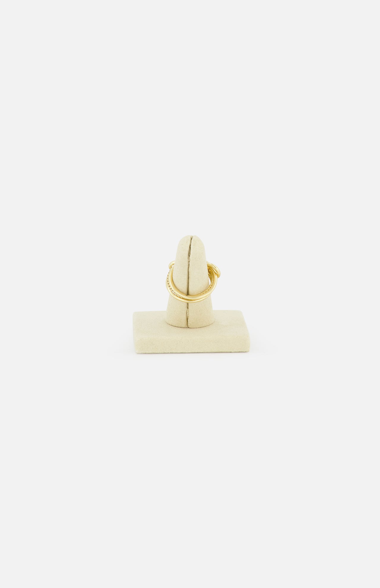 The SPINELLI KILCOLLIN Sonny Pavé Band Ring in yellow gold is displayed on a beige vertical ring holder, set against a plain white background to highlight the brand’s signature style.