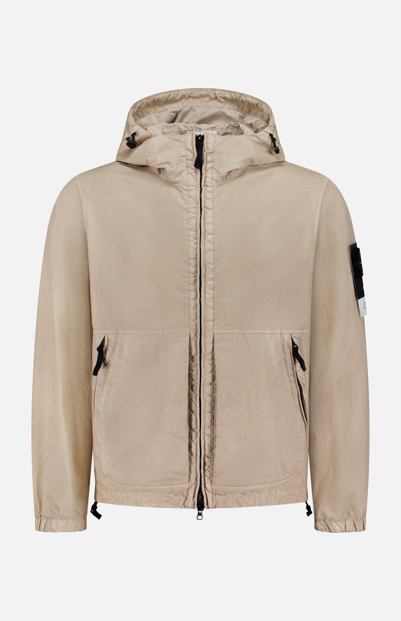 The STONE ISLAND Hooded Full Zip Drawcord Jacket in beige features two front pockets, a black zipper, adjustable hem drawstrings, and a black patch with white tag on the left sleeve, made from innovative Japanese fabric and shown on a white background.