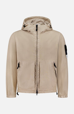 The STONE ISLAND Hooded Full Zip Drawcord Jacket in beige features two front pockets, a black zipper, adjustable hem drawstrings, and a black patch with white tag on the left sleeve, made from innovative Japanese fabric and shown on a white background.
