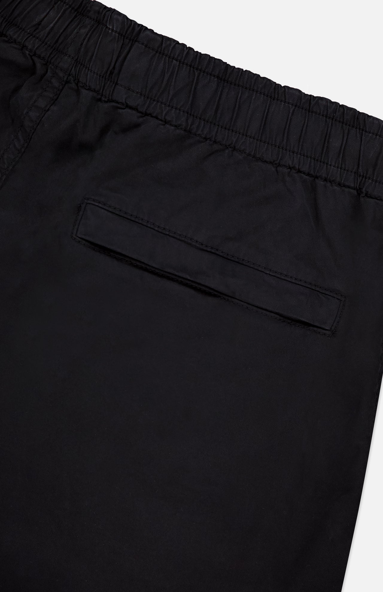 Close-up of the back of STONE ISLAND Drawstring Cargo Trouser Pant in black, featuring an elastic waistband and single welt pocket—a sleek streetwear essential.