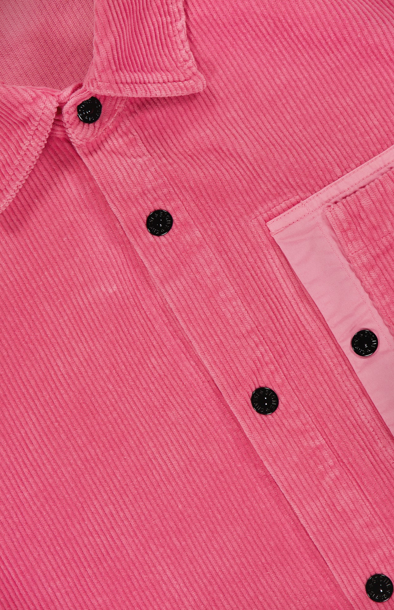 Close-up of the STONE ISLAND Corduroy Chest Pocket Overshirt in pink, featuring black buttons, a collar, and a flap chest pocket. The corduroy's vertical ridges enhance its streetwear style.