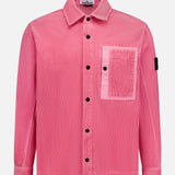 The STONE ISLAND Corduroy Chest Pocket Overshirt is a pink, long-sleeve button-up with a large chest pocket and black sleeve patch, inspired by classic overshirt style. Shown on a white background and perfect for streetwear.