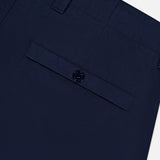 Close-up of the back pocket area of STONE ISLAND Ghost Cargo Trouser Pants in dark navy, showing a buttoned flap pocket and belt loop at the waistband, merging signature utility with refined sportswear style.