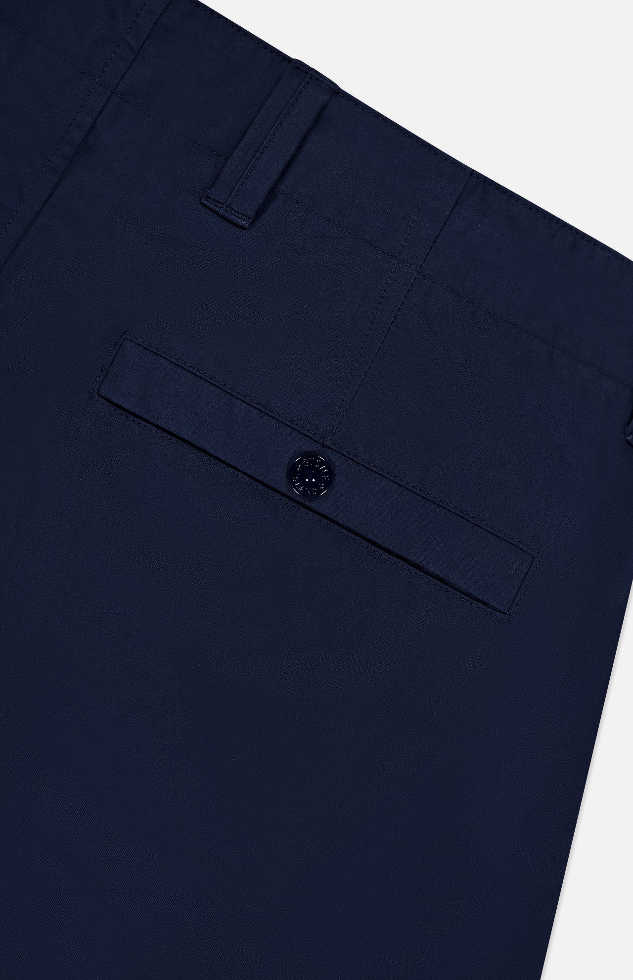 Close-up of the back pocket area of STONE ISLAND Ghost Cargo Trouser Pants in dark navy, showing a buttoned flap pocket and belt loop at the waistband, merging signature utility with refined sportswear style.