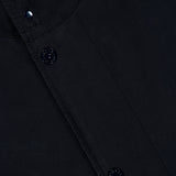 Close-up of the STONE ISLAND Ghost Hooded Short Parka Coat, showcasing its dark fabric, black buttons with subtle designs, and meticulous visible stitching—a refined men’s sportswear style characteristic of the brand. The smooth material and detailed buttons evoke signature elements often found in a Stone Island parka.