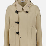 The STONE ISLAND Hooded Toggle Jacket in beige features black toggle closures, front pockets, and a high collar, displayed on a plain white background.