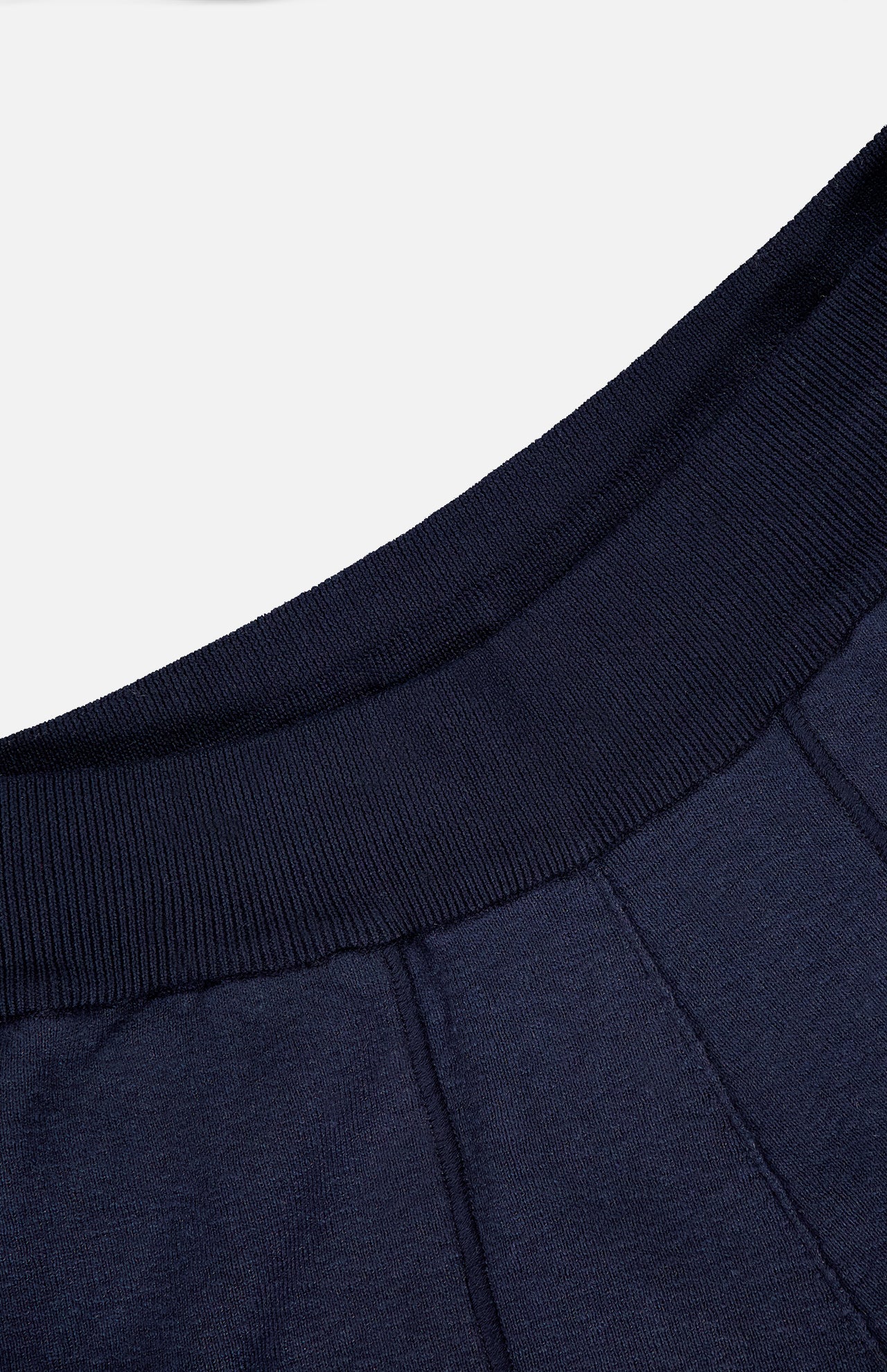 Close-up of STONE ISLAND Knitwear Drawstring Shorts in navy, featuring a ribbed waistband and vertical stitched seams on soft cotton-blend fabric.