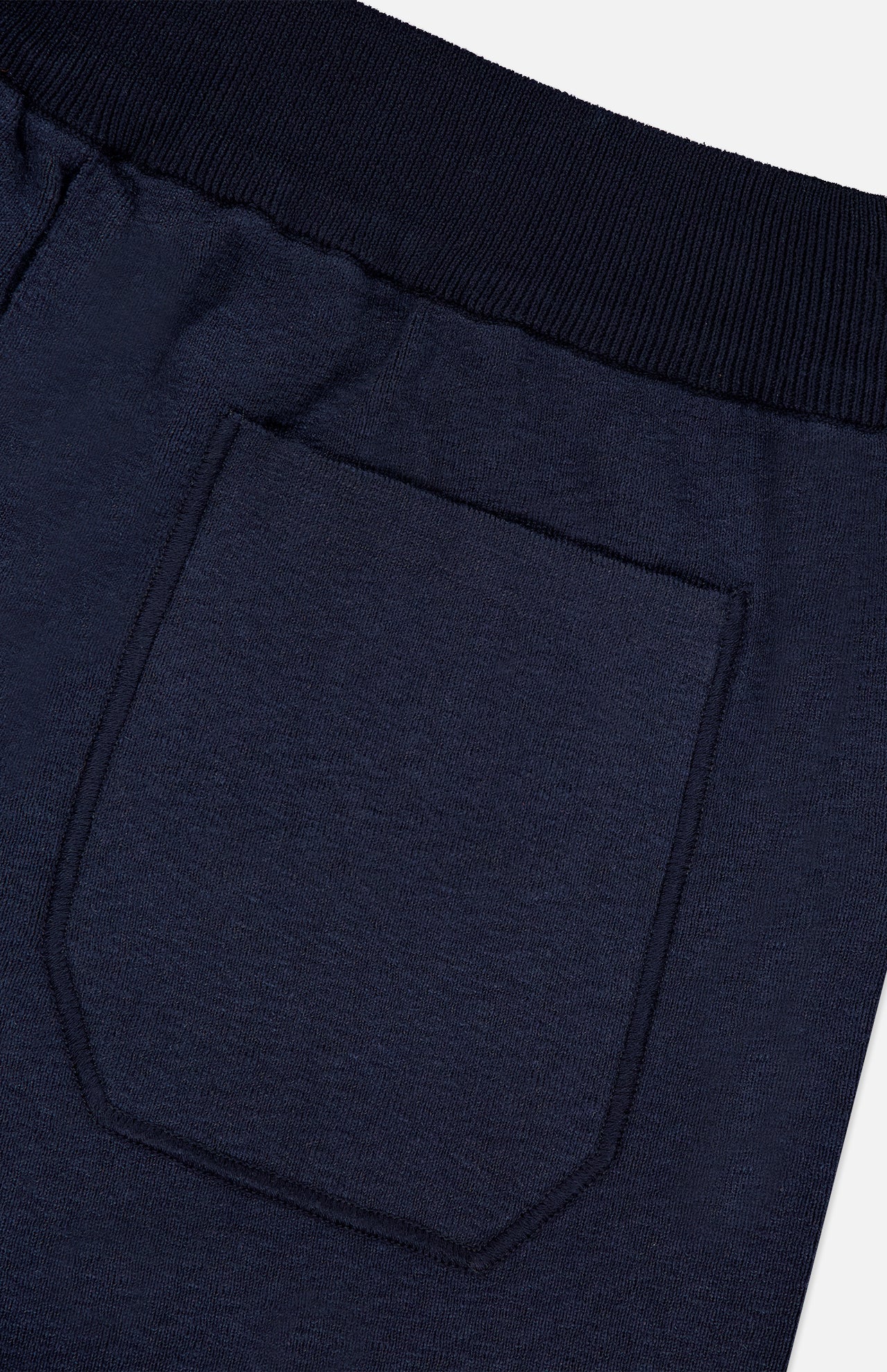 Close-up of the back pocket and waistband of STONE ISLAND Knitwear Drawstring Shorts in dark navy blue, highlighting the cotton-blend fabric’s texture and the stitching details around the pocket and waistband.