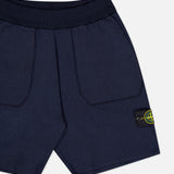 STONE ISLAND Knitwear Drawstring Shorts in navy, featuring large front pockets, ribbed waistband, and a black patch with the yellow-green compass logo on the left leg—crafted from a soft cotton blend for comfort.