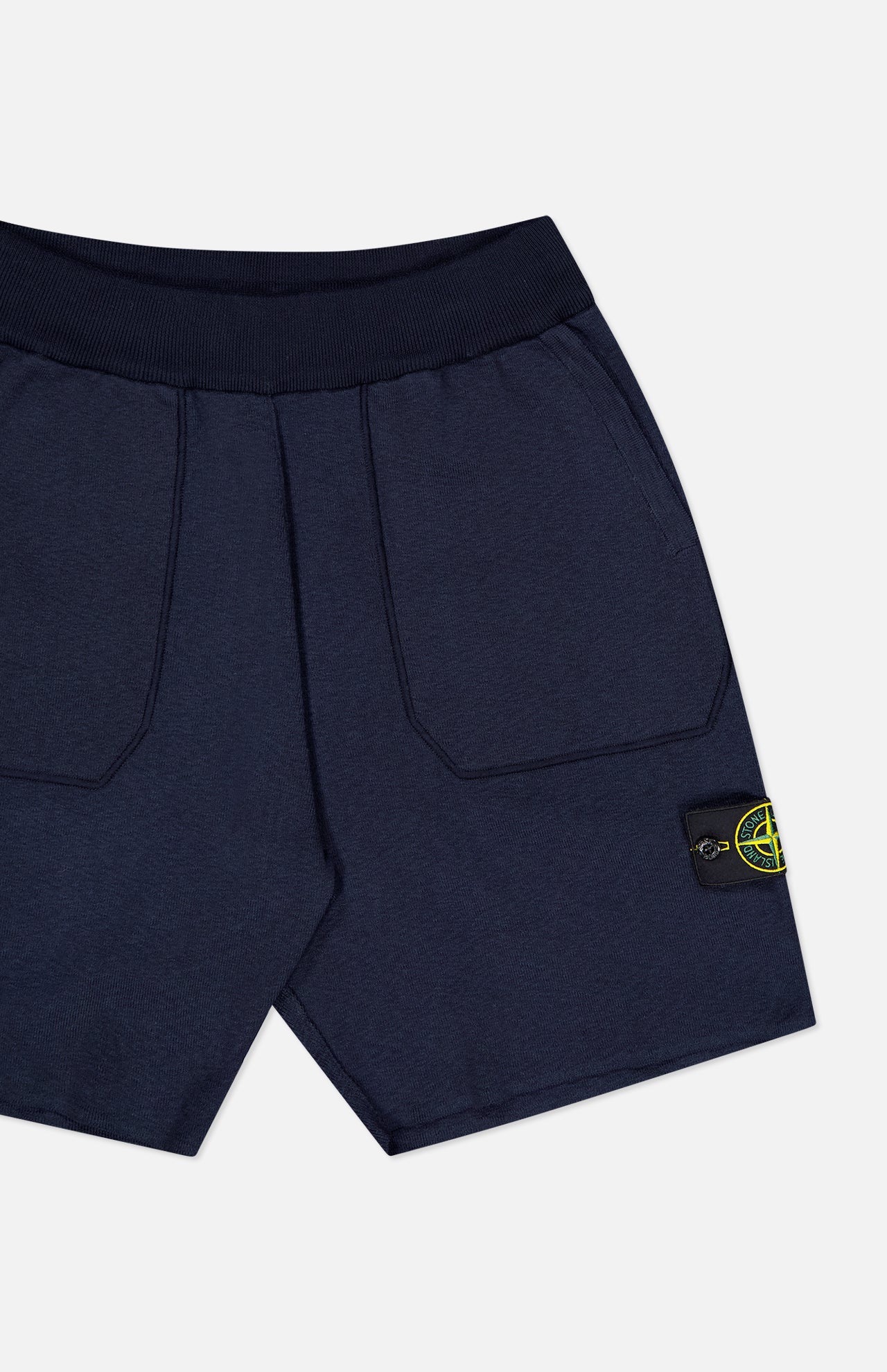 STONE ISLAND Knitwear Drawstring Shorts in navy, featuring large front pockets, ribbed waistband, and a black patch with the yellow-green compass logo on the left leg—crafted from a soft cotton blend for comfort.