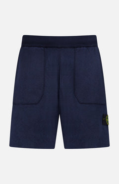 STONE ISLAND Knitwear Drawstring Shorts in navy cotton-blend feature an elastic waistband, front patch pockets, and a black and yellow logo patch on the left leg. Displayed against a plain white background.