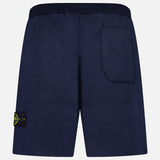 STONE ISLAND Knitwear Drawstring Shorts in navy, shown from the back with a right-side back pocket and a yellow-green logo patch on the left leg, made from a soft cotton-blend fabric.