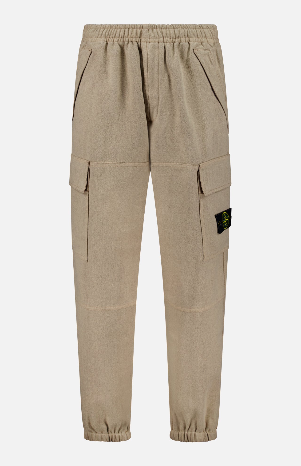 The Loose-Fit Cargo Jogger Pant by STONE ISLAND comes in beige with an elastic waistband and cuffs, side pockets, and spacious cargo pockets on the thighs. A black and yellow logo patch accents one pocket, giving these pants a bold yet versatile jogger-inspired style.