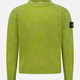 The STONE ISLAND Maglia Speck Crewneck Sweater is a lime green long-sleeve pullover with ribbed cuffs and hem, featuring the iconic black patch with yellow logo on the upper left arm. Displayed against a plain white background, this standout piece combines contemporary sportswear design with signature STONE ISLAND branding.