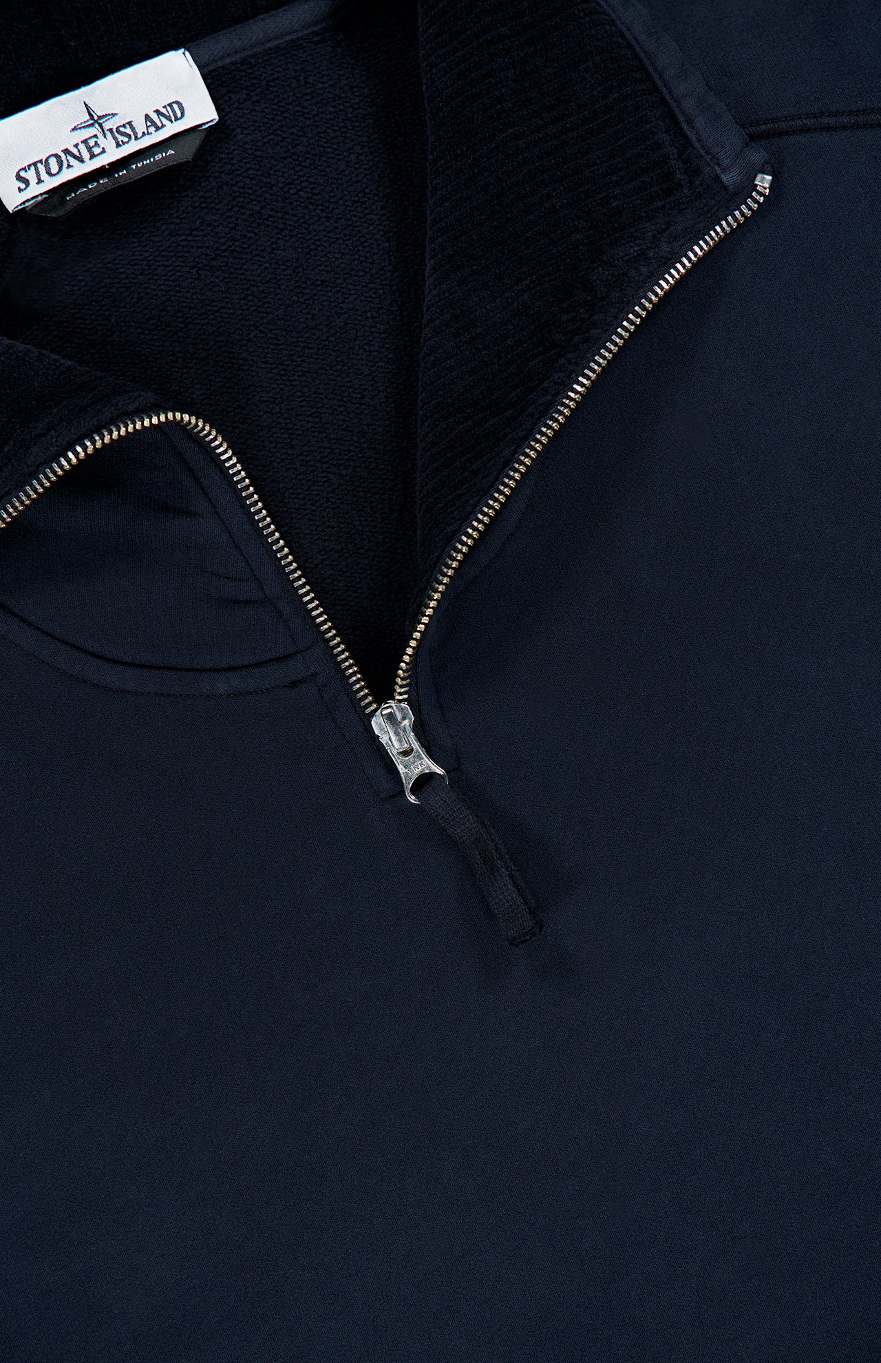 A close-up of the STONE ISLAND Quarter Zip Sweatshirt in navy blue, designed with a silver zipper and finished with the signature Stone Island label on the inside collar—a perfect blend of sportswear style and premium craftsmanship.