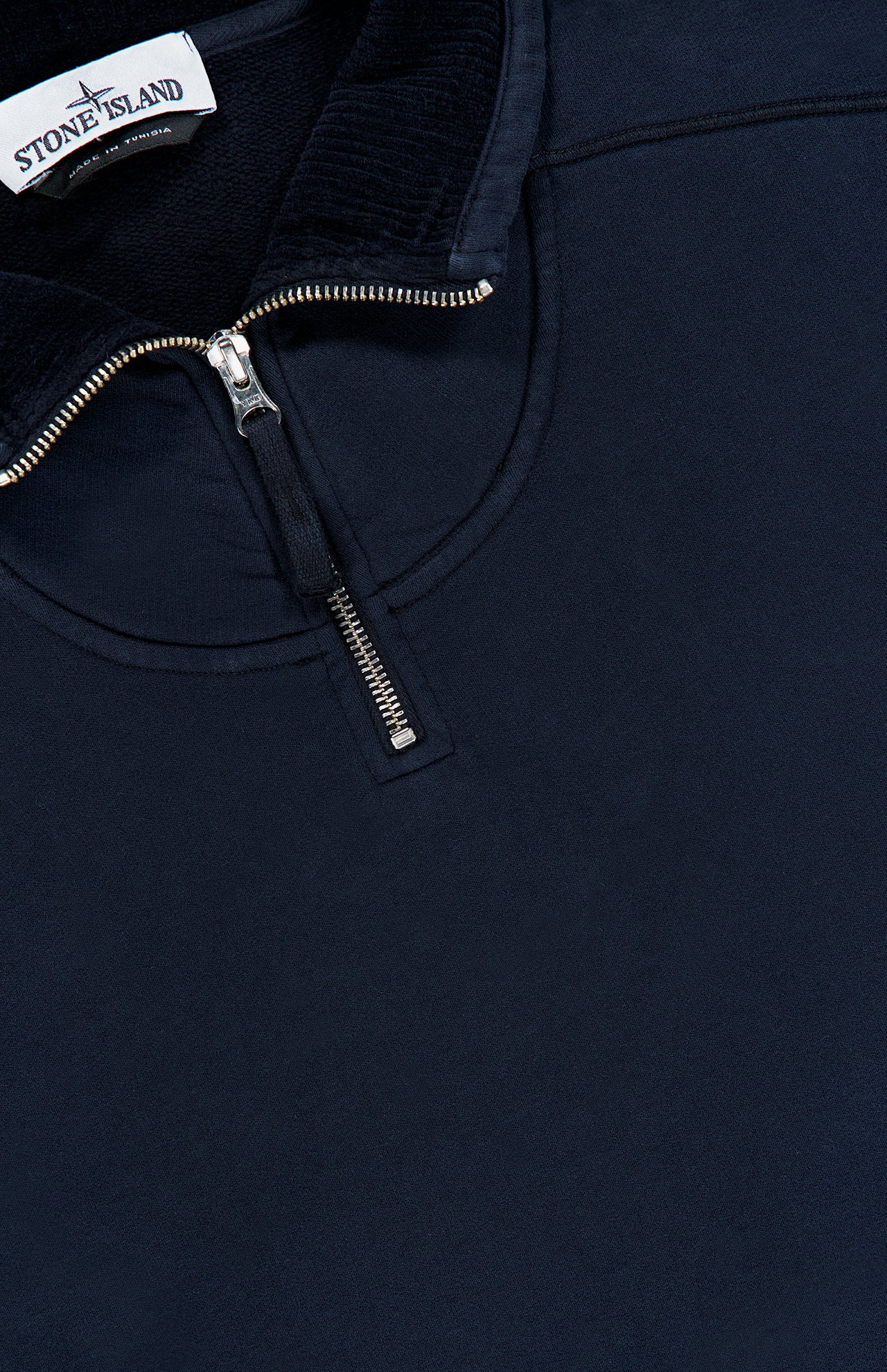 The STONE ISLAND Quarter Zip Sweatshirt in navy blue features a silver zipper and a branded label on the inside collar—an essential sportswear piece that blends comfort with premium design.