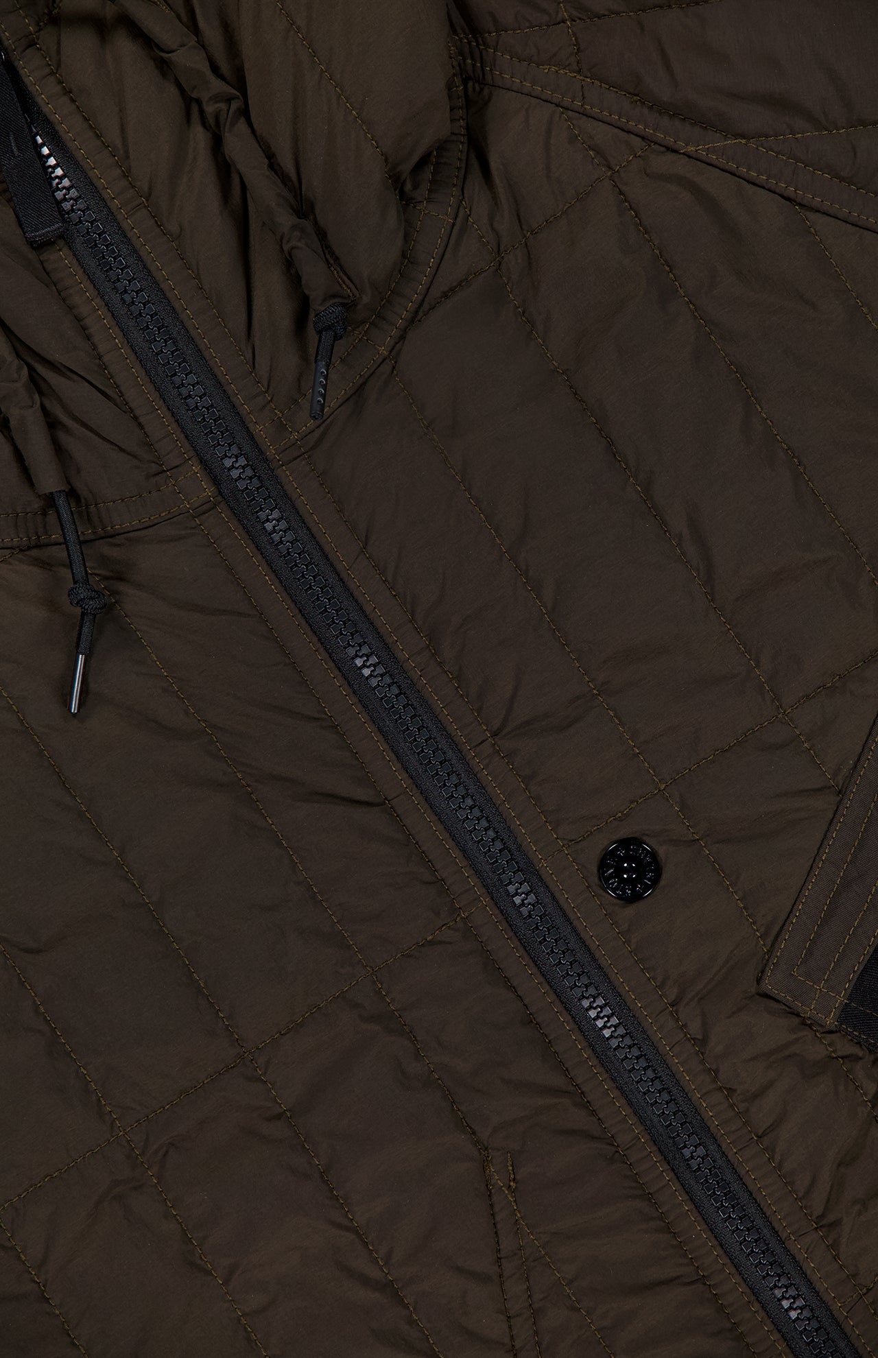 Close-up of the STONE ISLAND Quilted Hooded Jacket in brown, crafted from stretch nylon with a black zipper, a buttoned pocket, and visible quilting and stitching details inspired by the brand’s signature design elements.