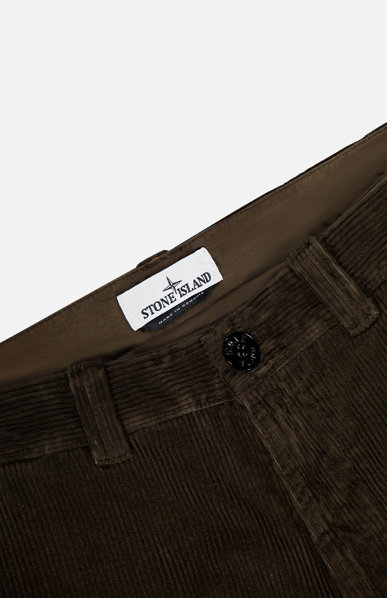 Close-up of brown STONE ISLAND Regular-Fit Corduroy Trouser Pants with a visible button, belt loops, and a white brand label inside the waistband—a standout in men's designer sportswear.