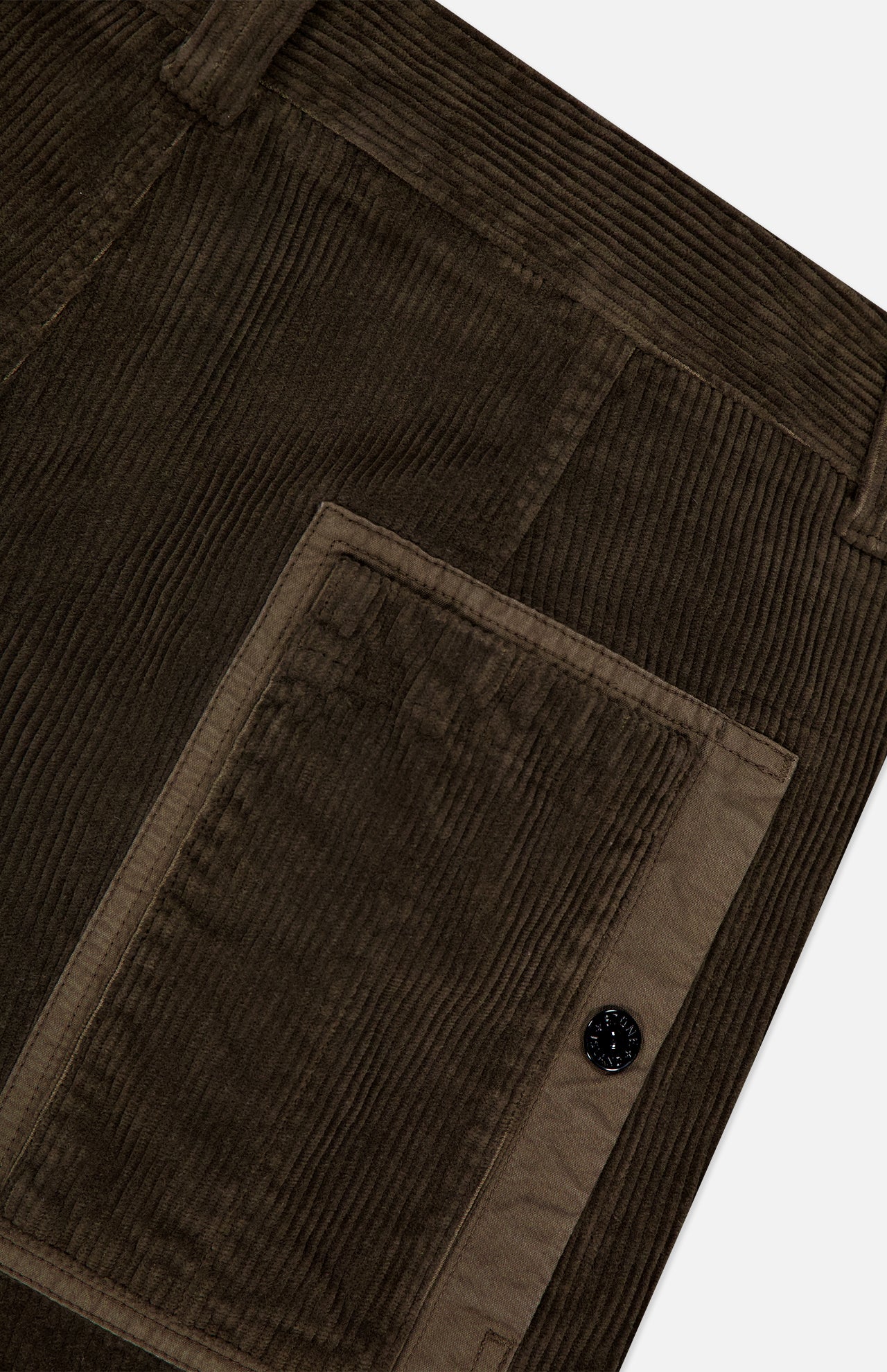 Close-up of dark olive green corduroy fabric with a textured vertical rib pattern and large rectangular pocket with button closure—signature elements of STONE ISLAND Regular-Fit Corduroy Trouser Pants.