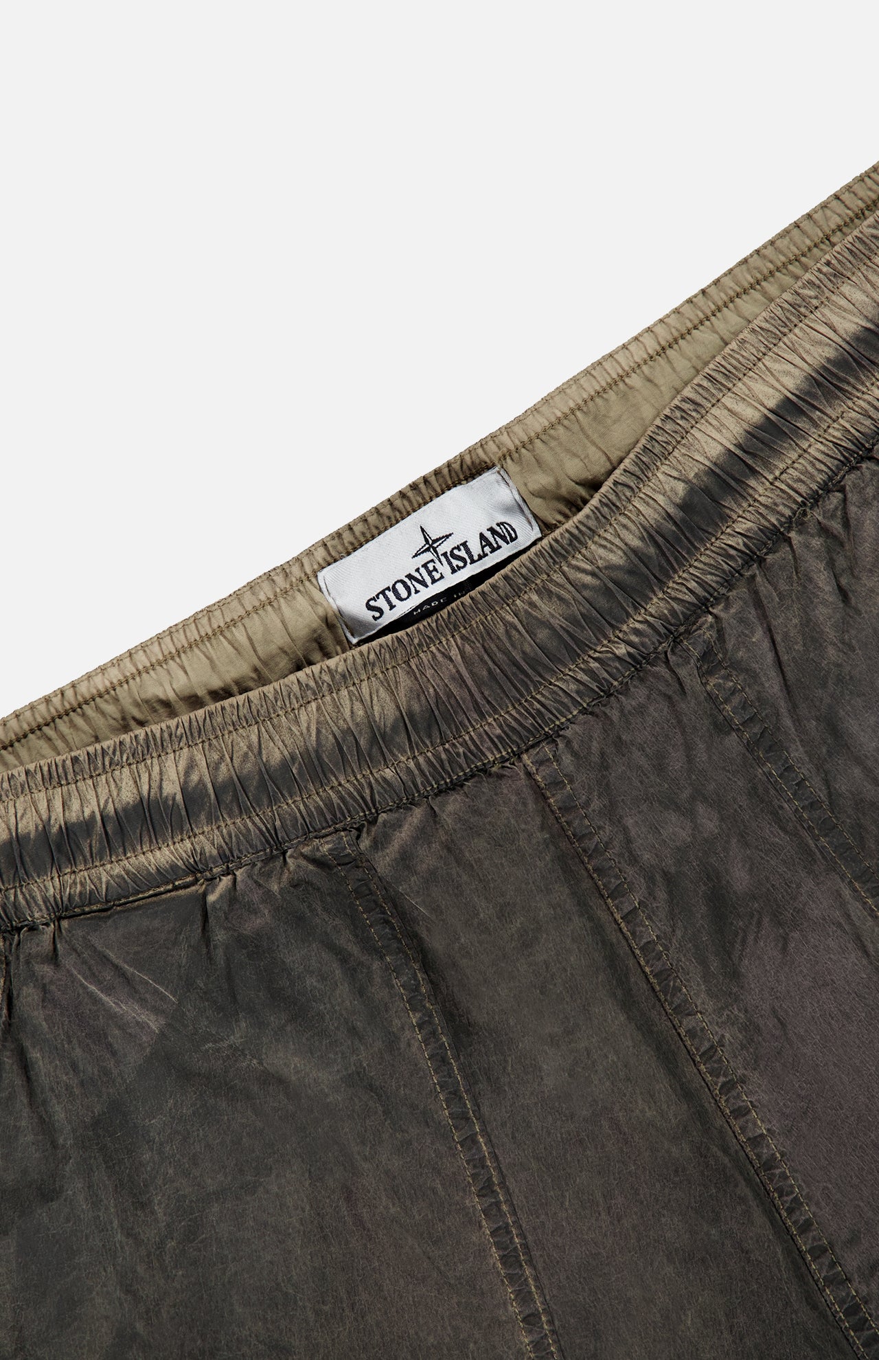 Close-up of the waistband of STONE ISLAND Regular-Fit Pattern Trousers in brown, showcasing the gathered elastic and brand label sewn inside, a detail that highlights the brand’s signature technical construction.