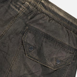 Close-up of STONE ISLAND Regular-Fit Pattern Trousers in a dark hue, featuring an elastic waistband and a back pocket with a flap secured by two black buttons, expertly crafted with technical construction for enhanced durability.