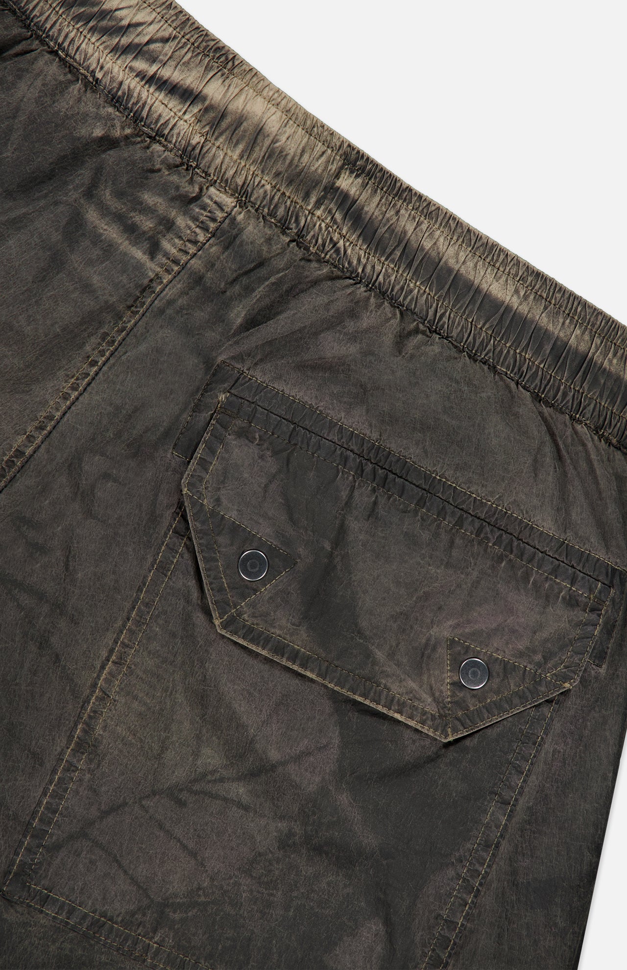 Close-up of STONE ISLAND Regular-Fit Pattern Trousers in a dark hue, featuring an elastic waistband and a back pocket with a flap secured by two black buttons, expertly crafted with technical construction for enhanced durability.