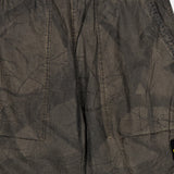 Close-up of the STONE ISLAND Regular-Fit Pattern Trousers in brown, showcasing crinkled fabric with side pockets, visible stitching, an elastic waistband, and a subtly textured finish—reflecting the brand’s signature technical construction.