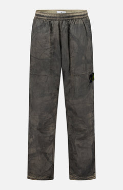 STONE ISLAND Regular-Fit Pattern Trousers in a brownish-grey shade, featuring loose fitting, an elastic waistband, side pockets, and a small black logo patch on the left leg, crafted with technical construction and shown against a plain white background.