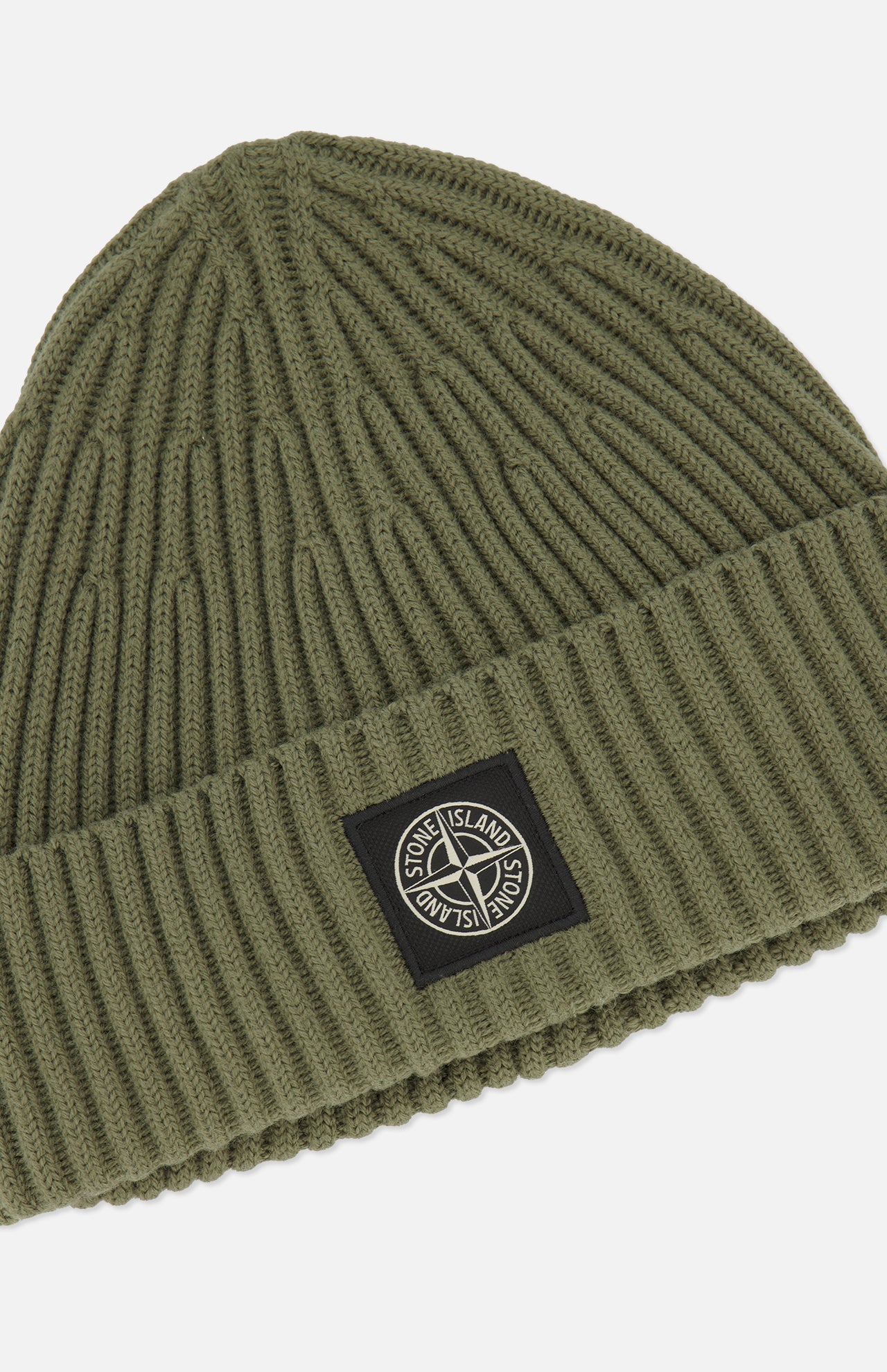 A military green STONE ISLAND Ribbed Wool Beanie with a folded cuff, featuring a black rectangular patch with the signature Stone Island compass logo on the front.
