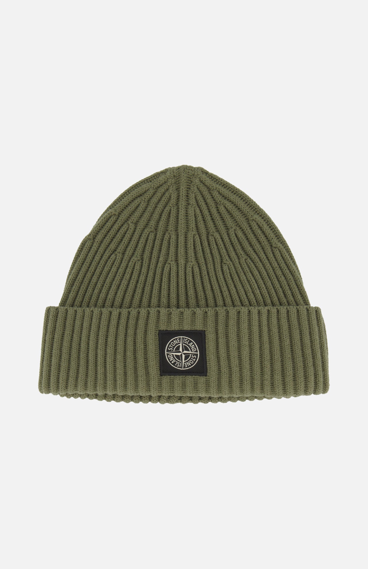 STONE ISLAND’s Ribbed Wool Beanie in olive green features a folded brim and showcases a black and white circular logo patch at the front center. This classic military green accessory stands out against a plain white background.