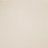 Close-up of SUNSPEL's Classic Short Sleeve T-Shirt in light beige, laid flat to showcase its smooth, soft cotton fabric. The collar and label with brand and size are visible; this timeless tee is crafted in Portugal.