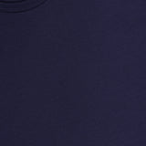 A close-up of the SUNSPEL Long Sleeve Classic T-Shirt, made from 100% cotton, showing part of the collar and a white tag with brand name and size. The smooth navy blue fabric highlights its soft quality.