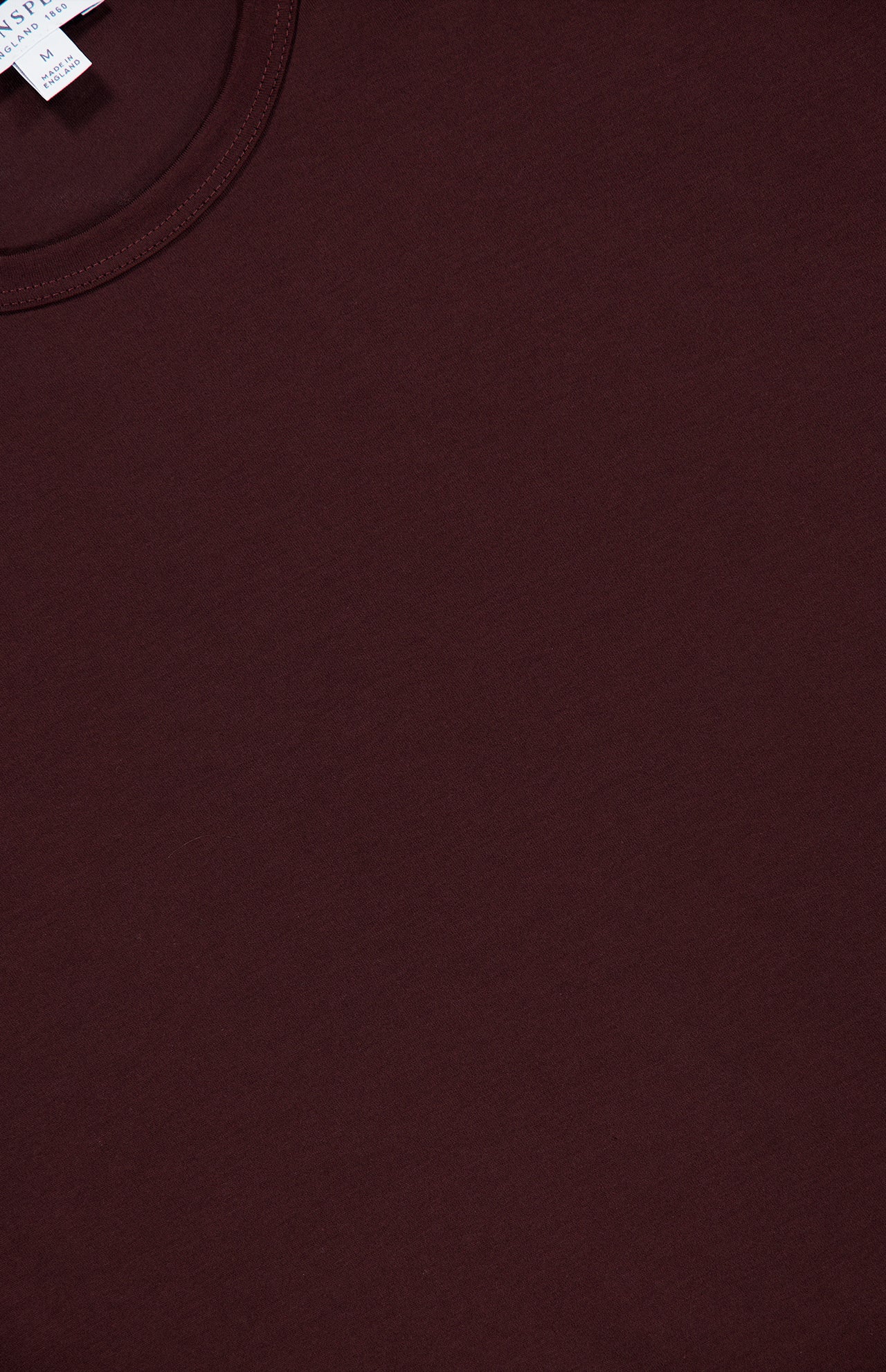 A close-up of the SUNSPEL Short Sleeve Classic T-Shirt in maroon, featuring a visible collar and part of the neck tag in the upper left corner, crafted from 100% cotton for enduring comfort.