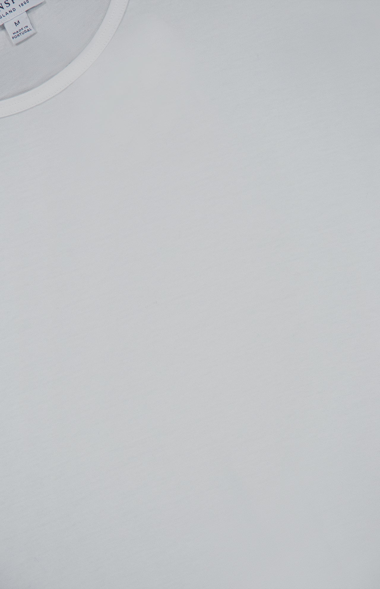 A close-up of the SUNSPEL Superfine Underwear T-Shirt laid flat, highlighting the fine texture of its long staple cotton fabric and part of the crew neck collar with a partially visible clothing tag.