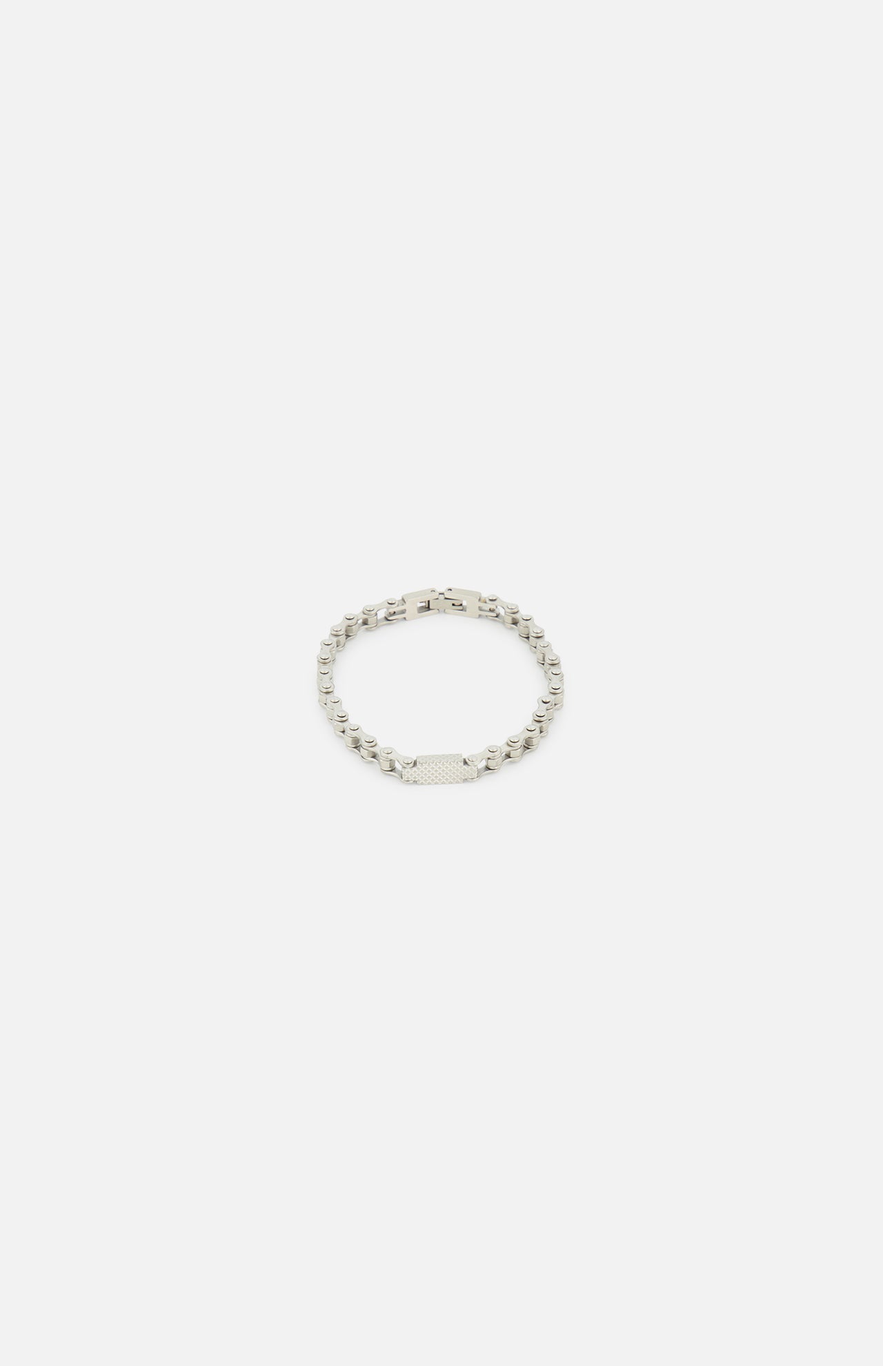 The TATEOSSIAN Bici Chain Bracelet features a rectangular, textured plate on a silver stainless steel chain, shown on a plain white background.